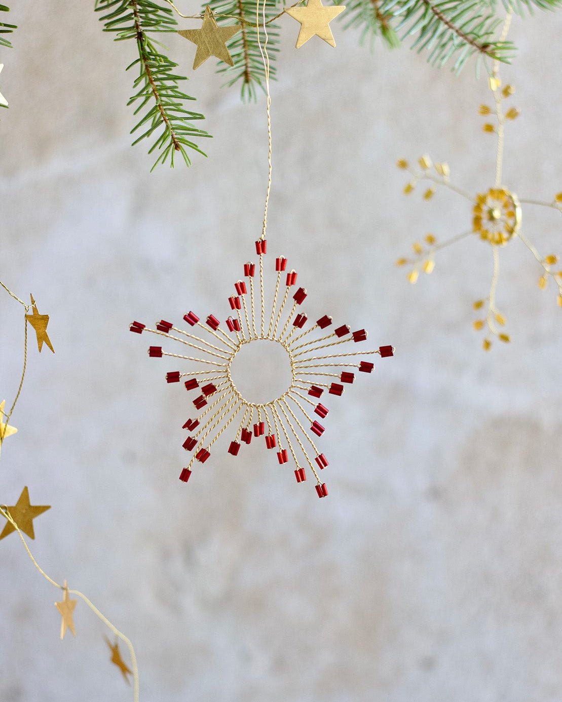 Decorative Christmas ornament with red and gold stars on a textured white background