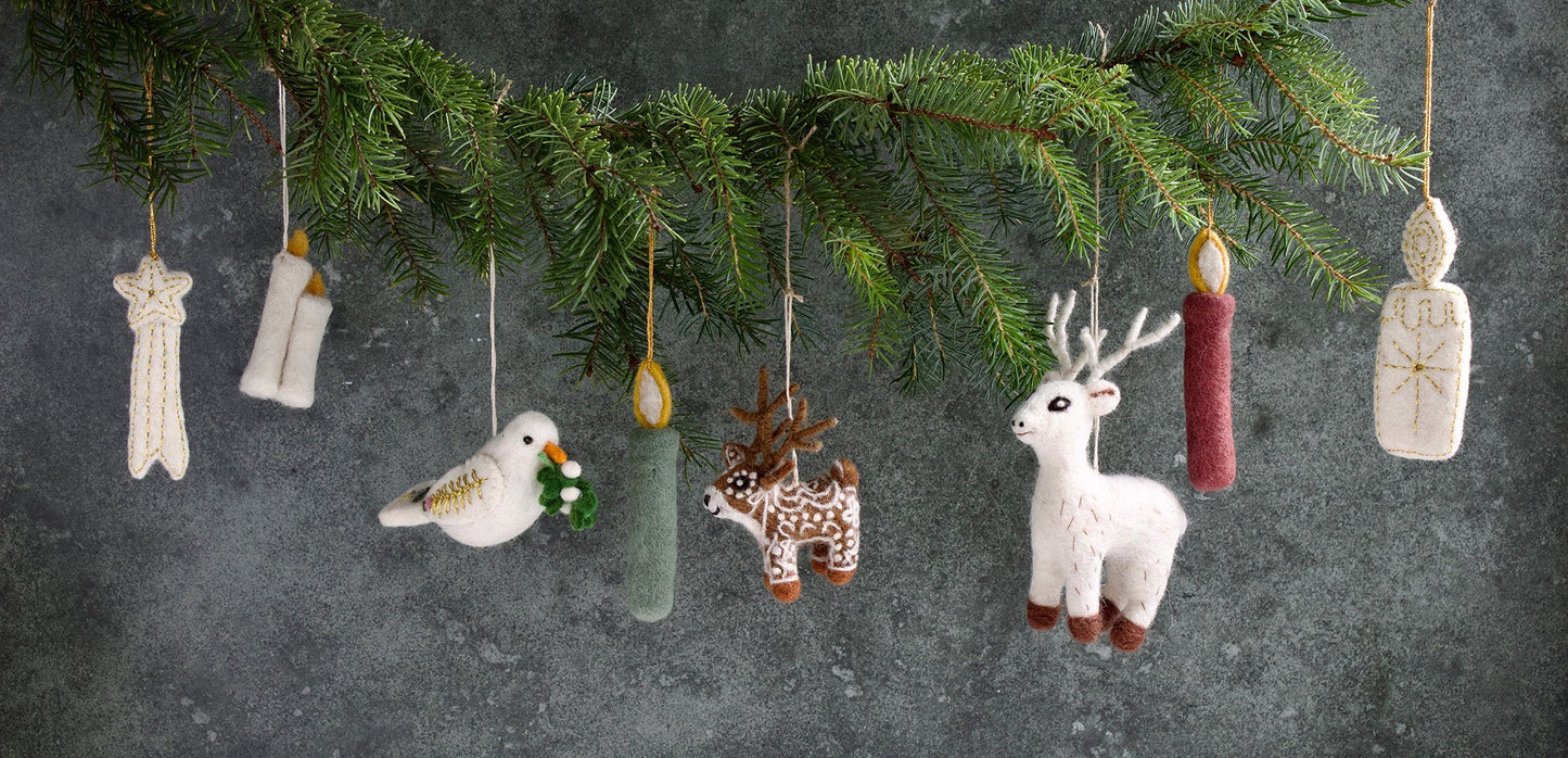 Decorative Christmas ornaments hanging from a branch against a dark background