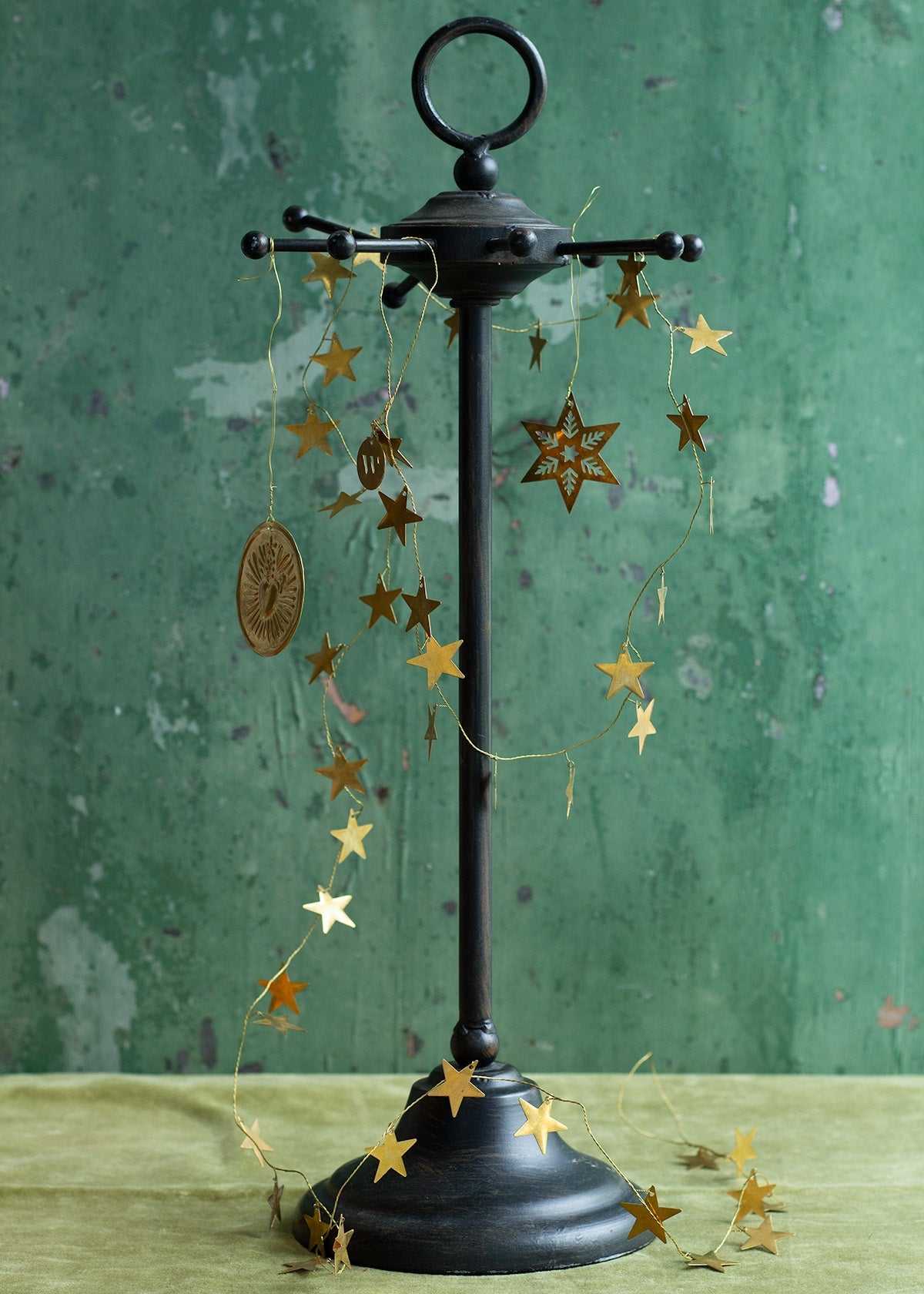 Decorative stand with hanging star-shaped ornaments against a green background