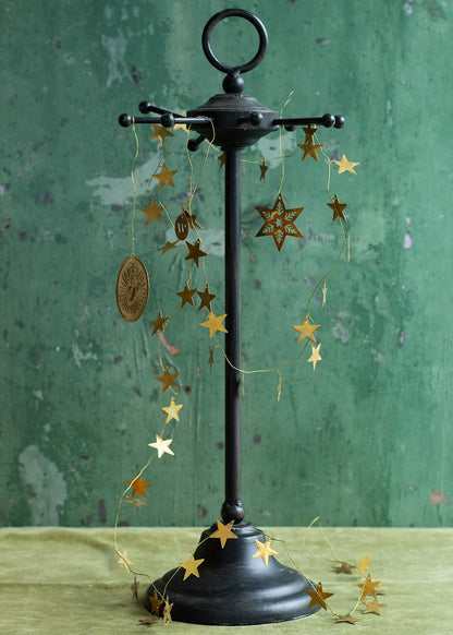 Decorative stand with hanging star-shaped ornaments against a green background