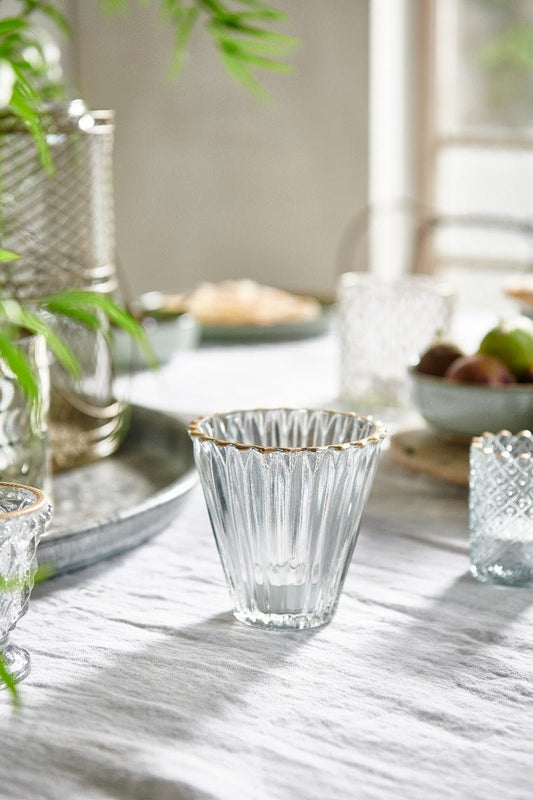 Clear glass bowls with gold rims on a marble surface
