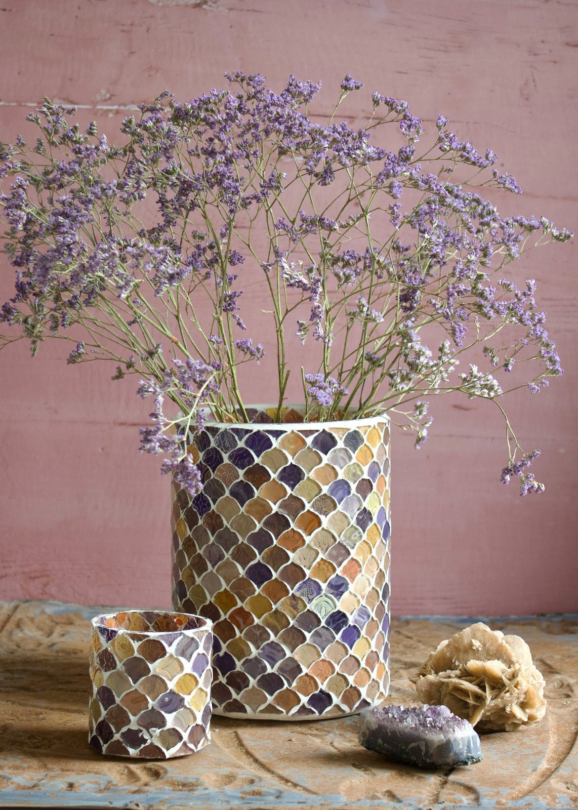 Handmade mosaic vases in warm terracotta and purple tones, featuring a scale-like pattern, styled with dried flowers and crystals.