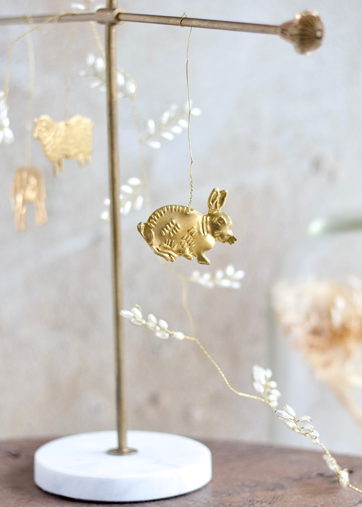 Gold rabbit ornament on a stand with blurred lights in the background