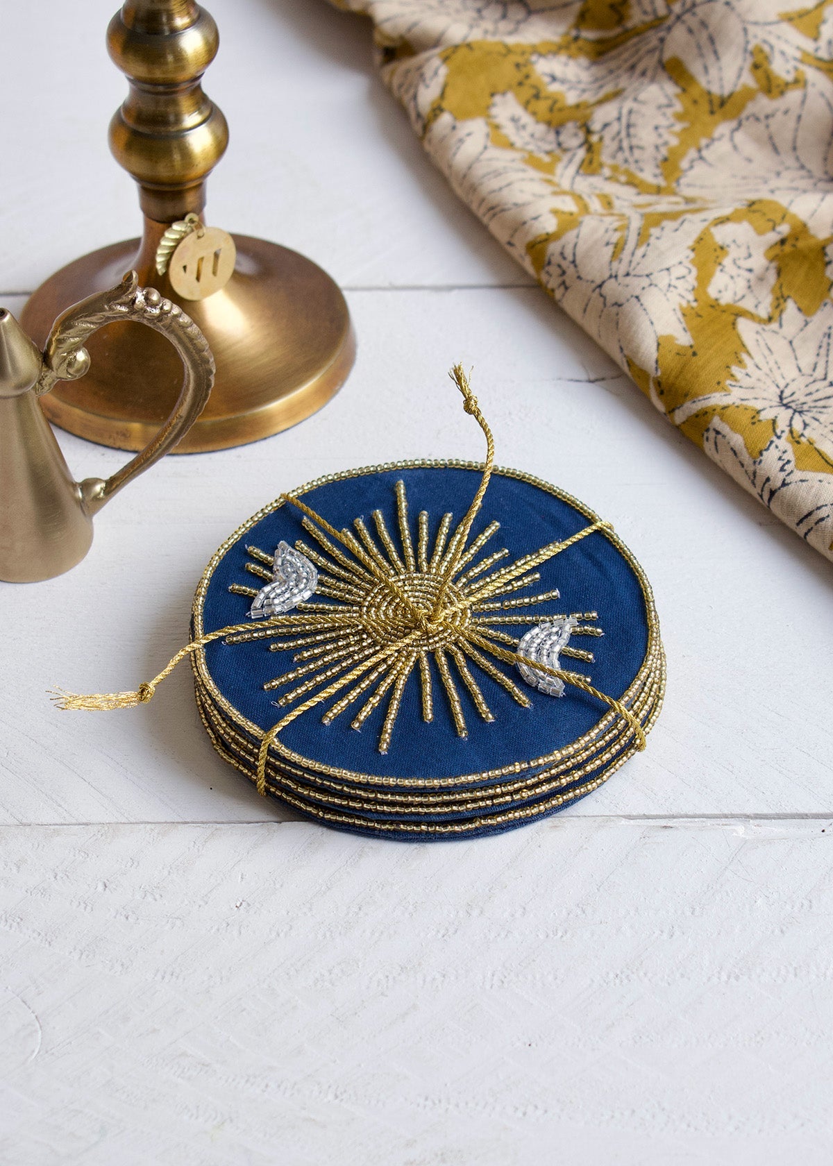 Set of blue coasters with gold embellishments on a white surface.